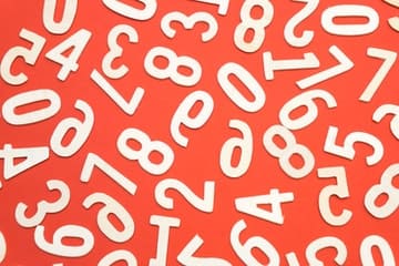 Números blancos desordenados sobre fondo naranja representando los fundamentos de la numerología